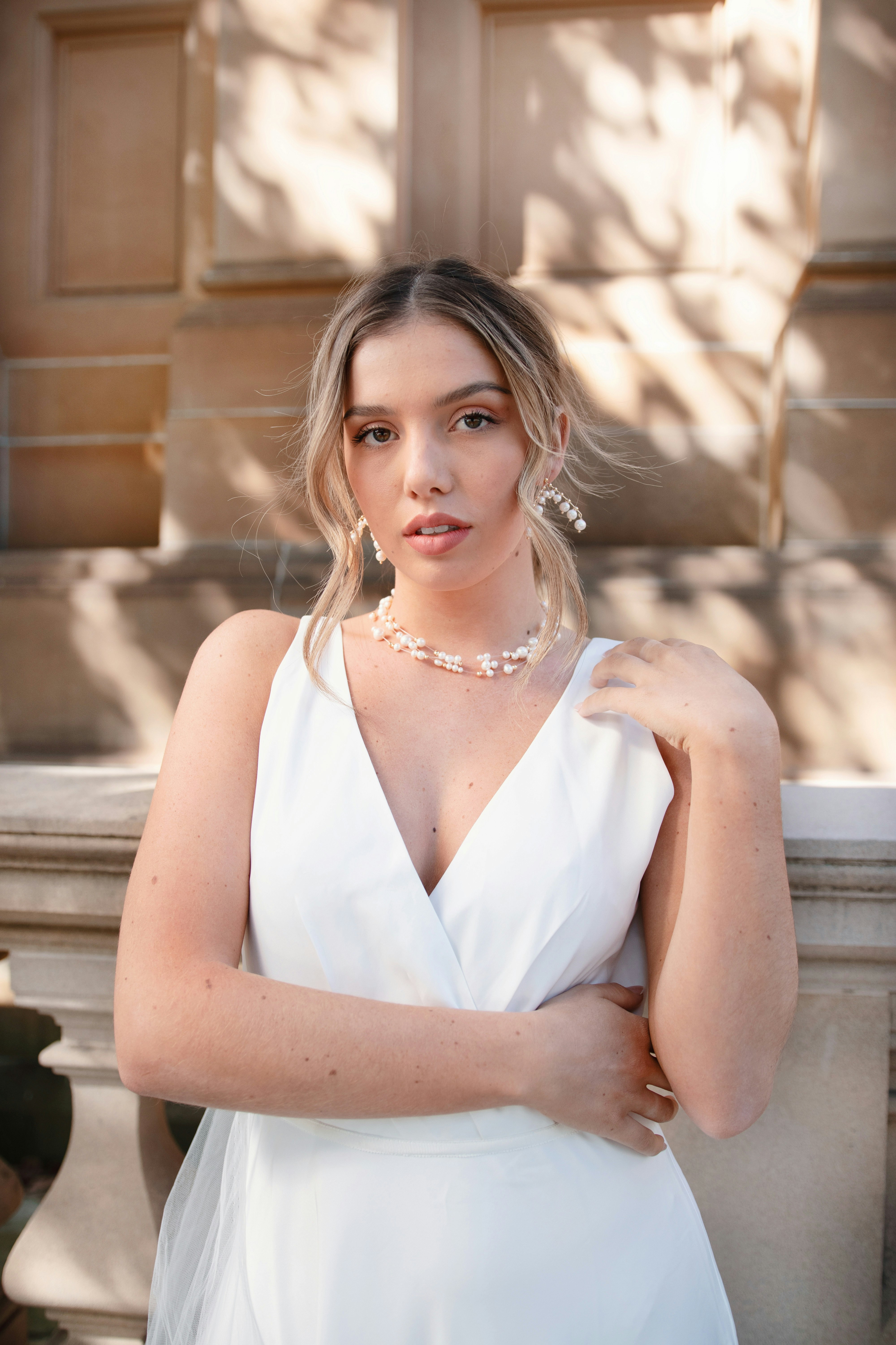 woman in white sleeveless top wearing silver necklace